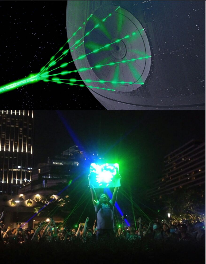 Two images. Top image is of the Death Star getting ready to fire a green beam of light. Bottom image is a photograph of a protestor holding up a reflector, into which the surrounding people are shining blue and green laser pointers, implying that the protestor in the bottom image is deflecting the shot from the Death Star.
